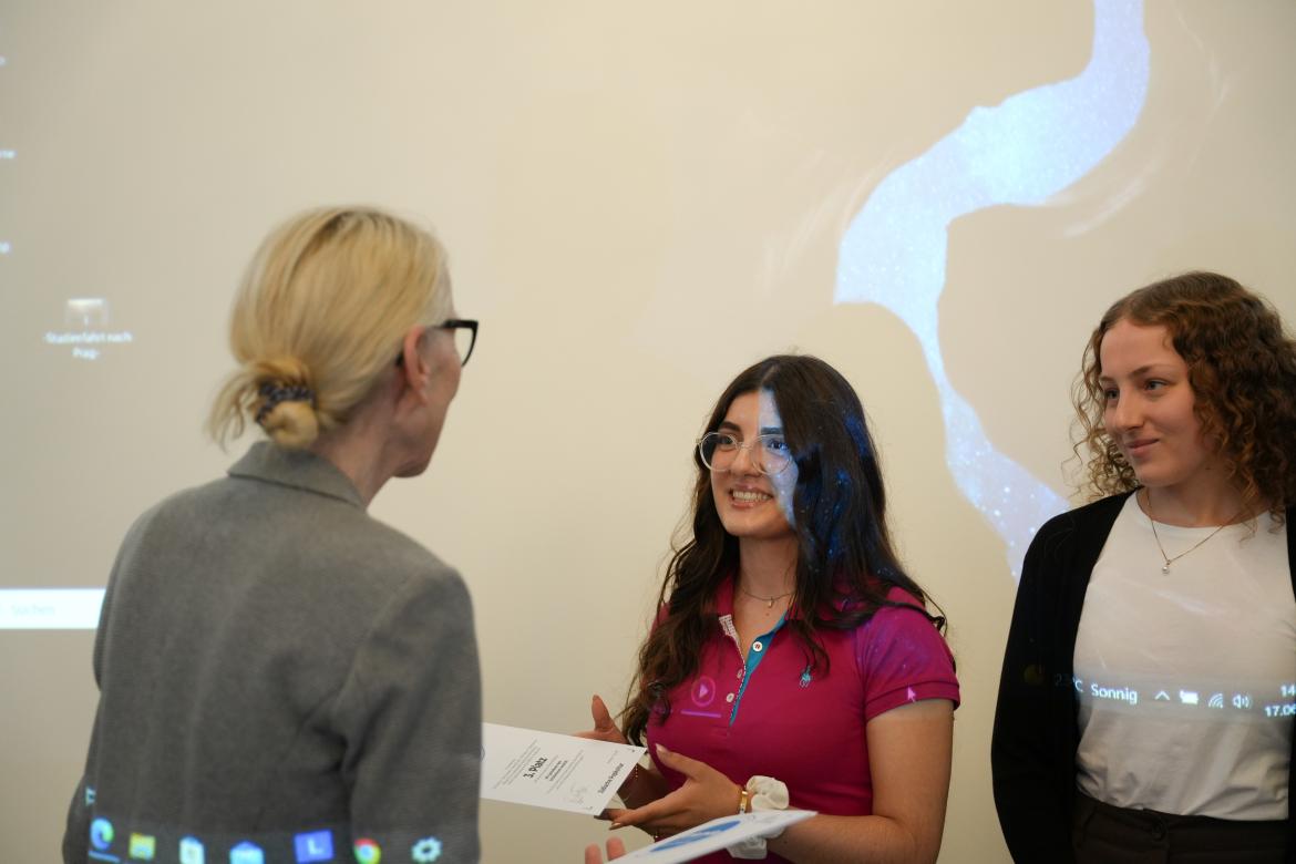 Gunda Trepp übergibt die Urkunden an die Preisträger*innen des 1. Platz.